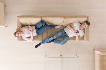 Image showing Young couple on the sofa watching television top view