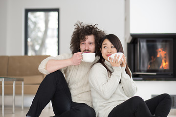 Image showing happy multiethnic couple  in front of fireplace