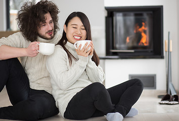 Image showing happy multiethnic couple  in front of fireplace