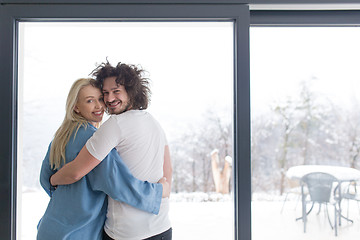 Image showing young couple enjoying morning coffee by the window