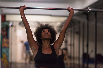 Image showing black woman lifting empty bar