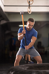 Image showing man workout with hammer and tractor tire