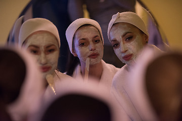 Image showing women putting face masks in the bathroom