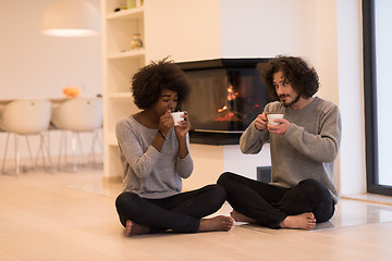 Image showing multiethnic couple  in front of fireplace