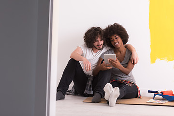 Image showing young multiethnic couple relaxing after painting