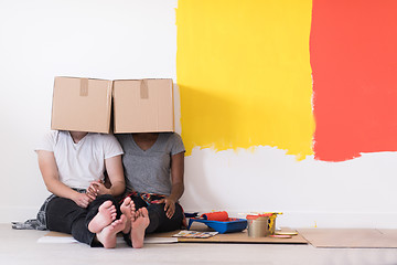 Image showing young multiethnic couple playing with cardboard boxes