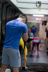 Image showing man workout with hammer and tractor tire