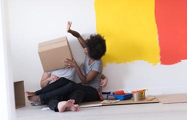 Image showing young multiethnic couple playing with cardboard boxes