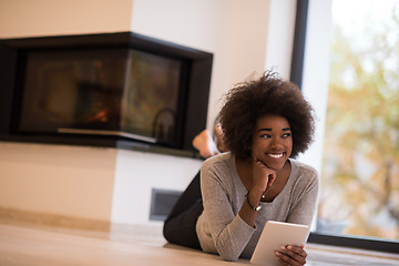 Image showing black women using tablet computer on the floor