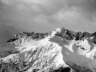 Image showing Black and white view on snow sunlight mountain and cloudy sky at