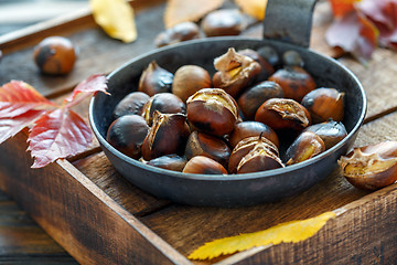 Image showing Roasted chestnuts in a cast iron skillet.
