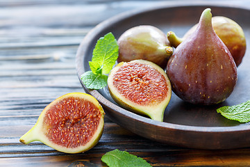 Image showing Fresh figs and mint leaves on a wooden dish.