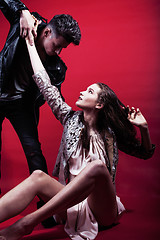 Image showing young fashion style couple man and woman on red sexy background, luxury stuff, lifestyle modern people sale concept