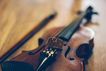 Image showing Old violin lying on a wooden surface