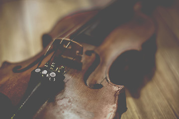 Image showing Old violin lying on a wooden surface
