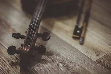 Image showing Old violin lying on a wooden surface