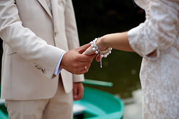 Image showing The groom gently holds the bride by the hand