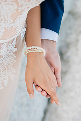 Image showing The groom gently holds the bride by the hand