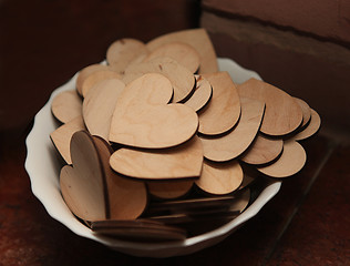 Image showing Carved wooden hearts on a white plate.