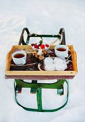 Image showing Romantic breakfast in the snow. Winter Vintage Sledge. Coffee, marshmallows, and other sweets