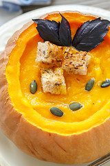 Image showing Pumpkin soup with croutons and purple basil closeup.