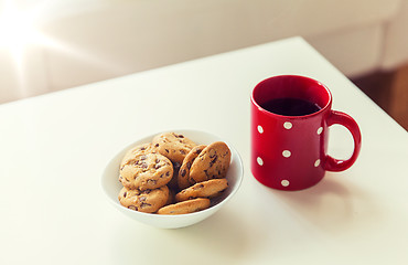 Image showing close up of oat cookies and red tea cup on table