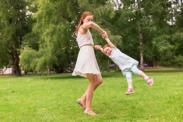 Image showing happy mother playing with baby girl at summer park