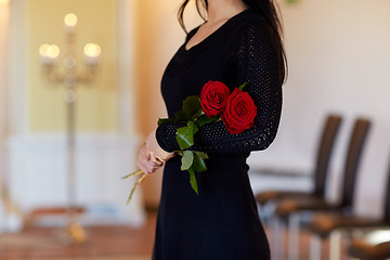 Image showing woman with red roses at funeral in church