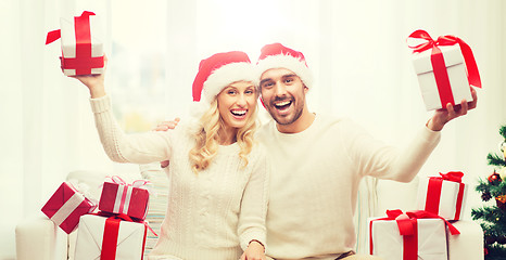 Image showing happy couple at home with christmas gift boxes