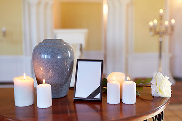 Image showing photo frame, cremation urn and candles in church