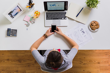 Image showing woman with smartphone and laptop at office table