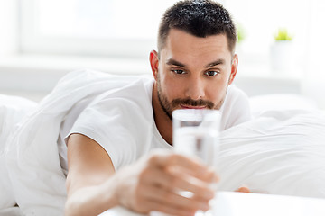 Image showing man in bed with glass of water at home