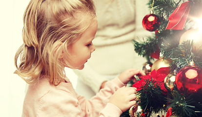 Image showing little girl decorating christmas tree at home