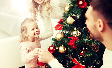 Image showing happy family decorating christmas tree at home