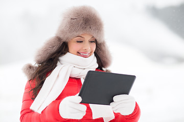 Image showing woman in winter fur hat with tablet pc outdoors