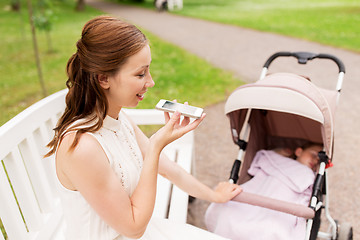 Image showing mother with stroller and smartphone at summer park