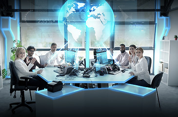 Image showing happy business team with earth hologram at office