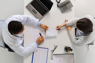 Image showing doctor giving prescription to patient at hospital