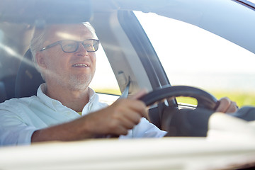 Image showing happy senior man in glasses driving car