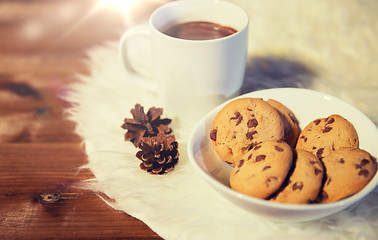 Image showing cups of hot chocolate with cookies on fur rug