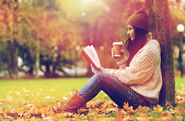 Image showing woman with book drinking coffee in autumn park