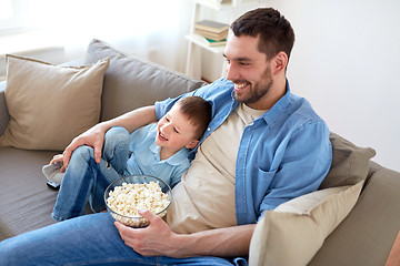 Image showing father and son with popcorn watching tv at home