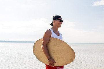 Image showing happy young man with skimboard on summer beach