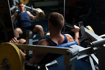 Image showing man doing chest press on exercise machine in gym