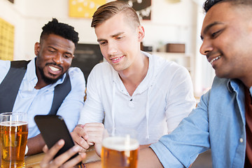 Image showing male friends with smartphone drinking beer at bar