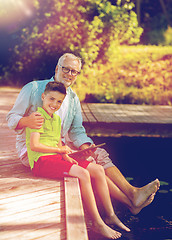 Image showing grandfather and boy with tablet pc on river berth