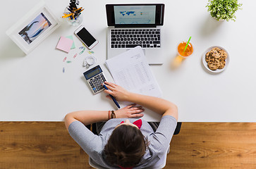 Image showing woman with calculator and papers at office table