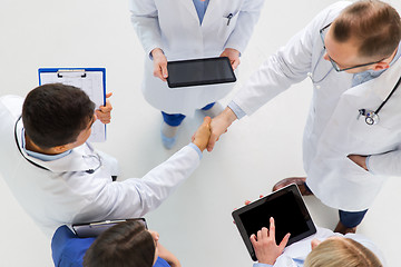 Image showing doctors with tablet pc doing handshake at hospital