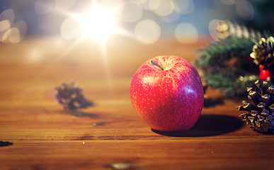 Image showing close up of apple with fir decoration on wood