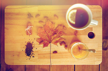 Image showing cup of lemon tea and honey on wooden board